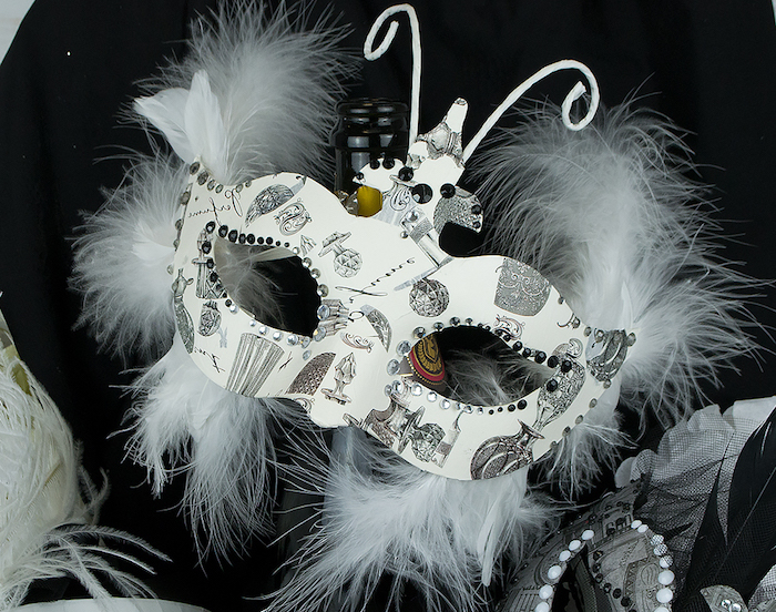 weiße Halloween Masken, ein Schmetterling mit weißen Flügel mit Zeichnungen als Motive