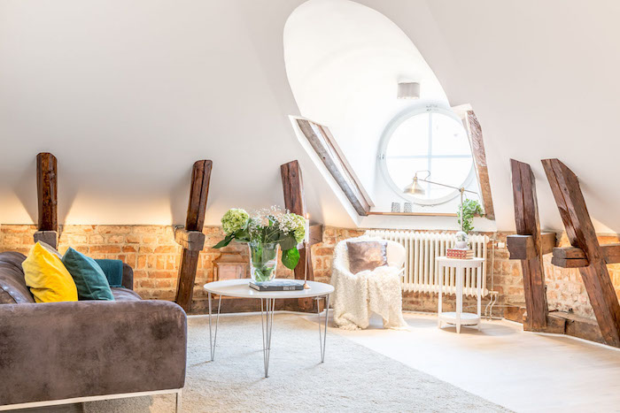 dachschräge einrichten tolle idee dezent elegant stilvoll rundes fenster hölzerne elemente an den wänden sofa