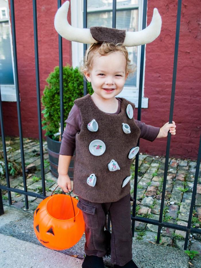 ein blonder Junge wie Stier gekleidet, kleine Tassen hängend - Halloween Kostüm Ideen für Kinder