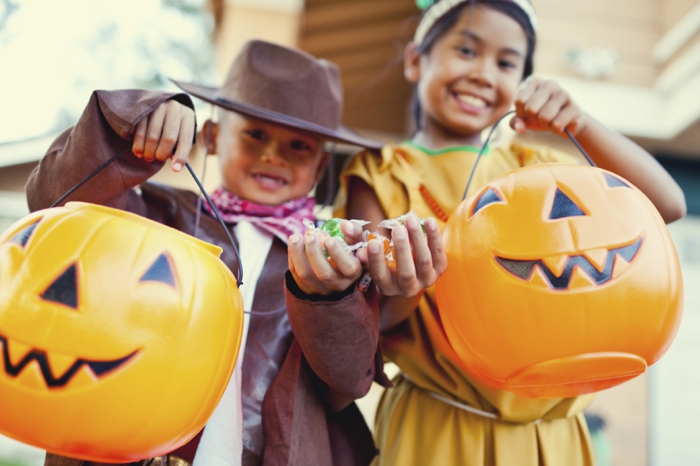 Süßigkeiten sammeln gehen, Mädchen und Junge mit tollen Halloween Kostümen, Trick or Treat