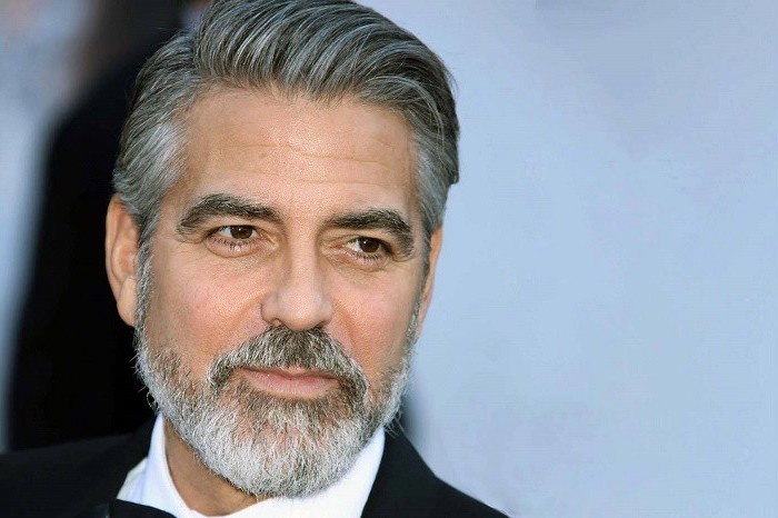 George Clooney mit Vollbart auf dem roten Teppich, weißes Hemd, schwarzer Anzug