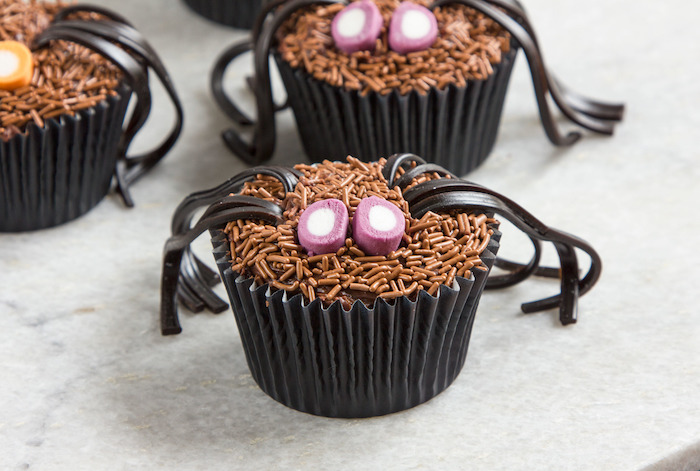 rezepte für halloween, spinnen aus cupcakes mit beinen aus schokolade