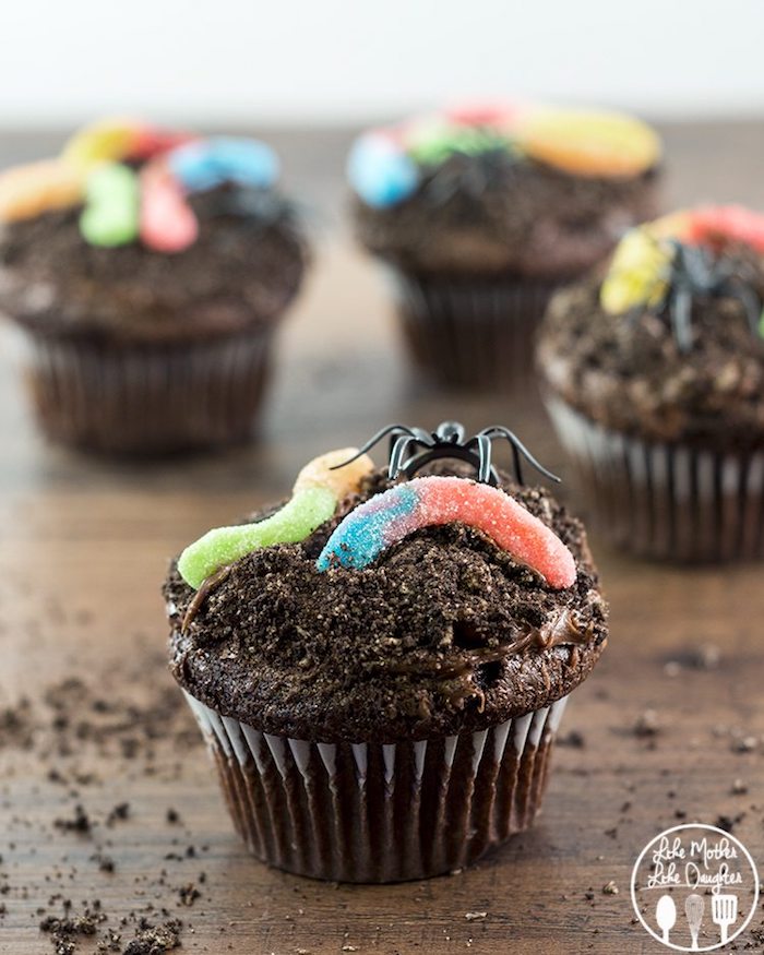 halloween gebäck, cupcakes dekoriert mit spinnen aus schokolade und gellebonbons