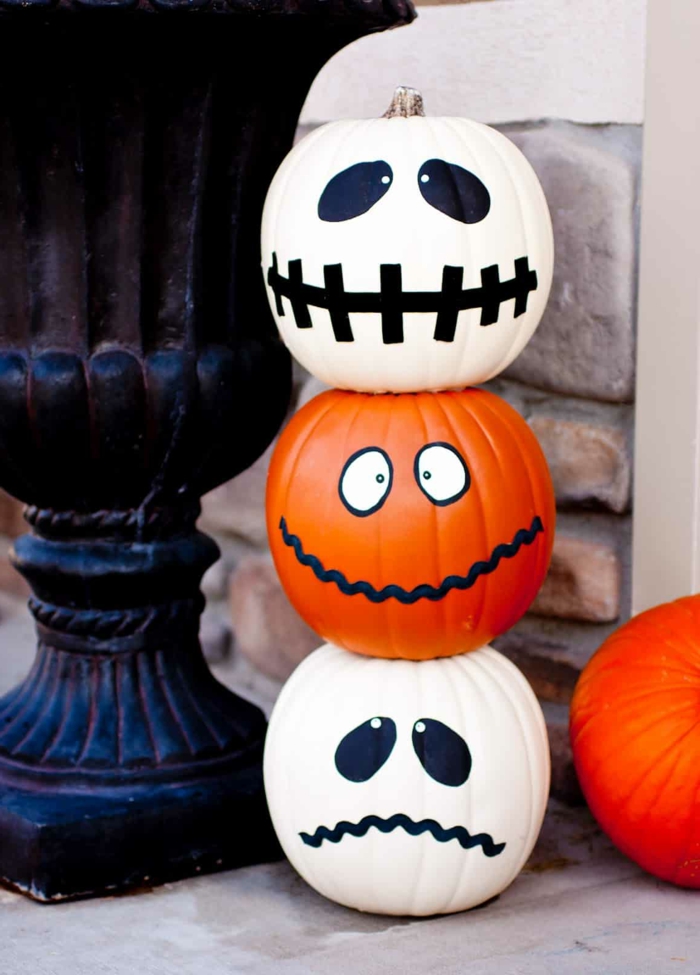 Kürbisse bemalen, Gesichter aufzeichnen, drei gruselige Mumien, Halloween Dekoideen für Ihren Garten