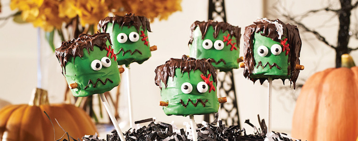 grüne Monster-Schaumzucker mit Schokoladenhaaren und roten Kreuzen