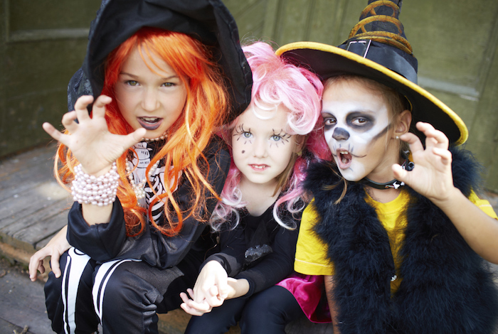 Halloween Kostüm für Kinder - zwei Mädchen und ein Junge wie Hexen verkleidet