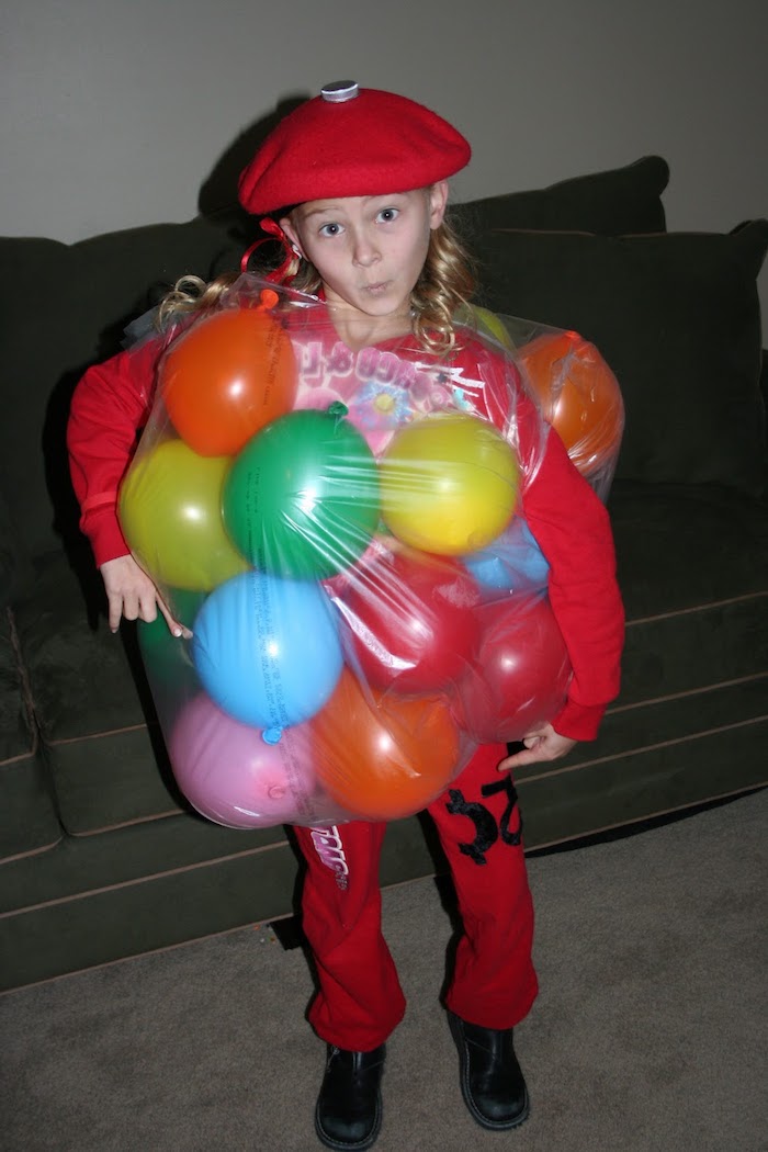 Halloween Kostüme für Kinder - ein Mädchen mit rotem Trainingsanzug und Ballonen, roter Hut 