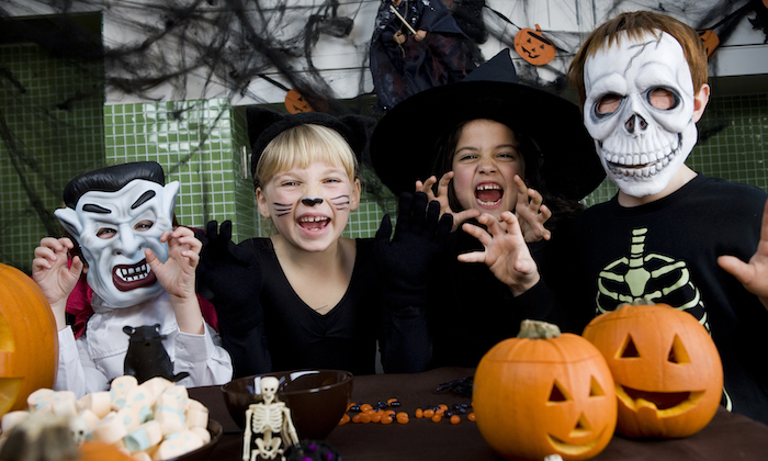 eine Gruppe von Kindern wie Vampir, schwarze Katze, Hexe und Skeleton maskiert - einfache Halloween Kostüme