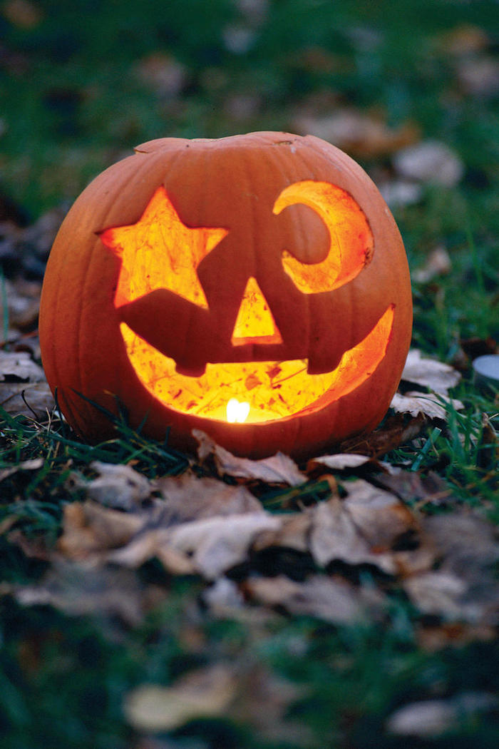 Halloween Bilder ein Kürbis auf Laub zwei Augen - ein Stern und ein Mond