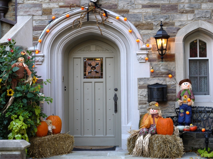 Eine Tür mit Lichterkette wie Kürbisse, Strohpuppen und Halloween Kürbisse