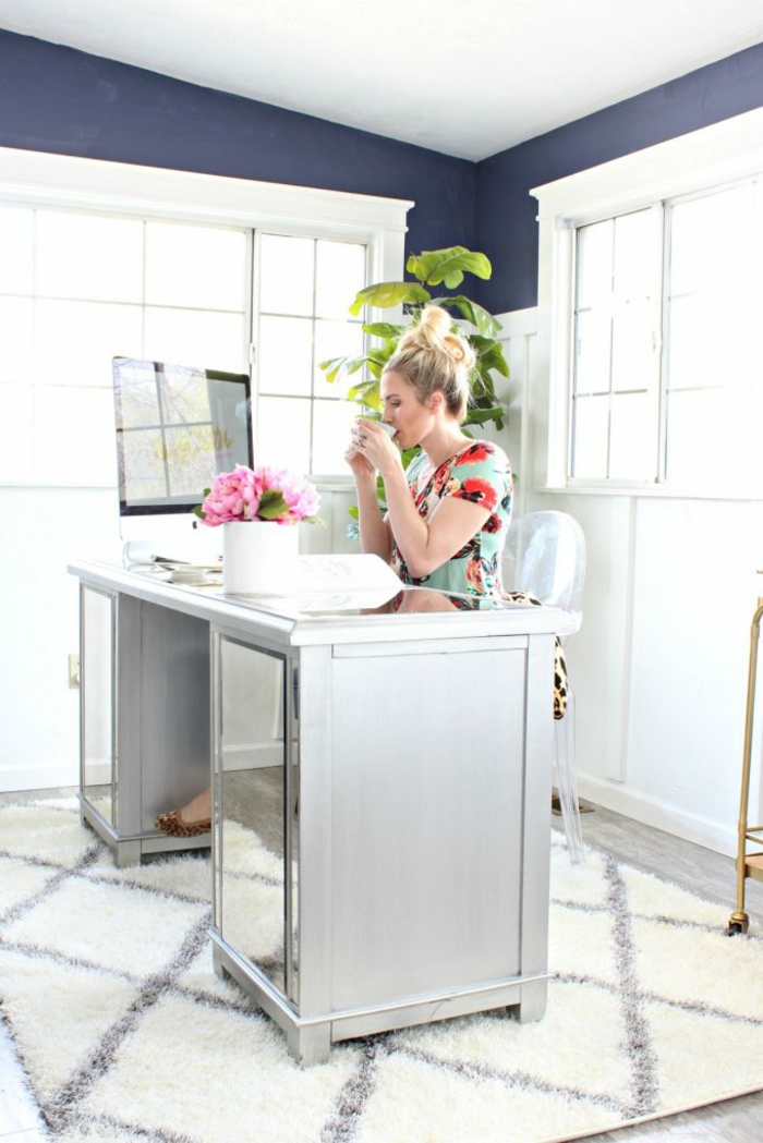 Arbeitszimmer Einrichtung, grauer Schreibtisch, Laptop und Blumenstrauss darauf, grüne Pflanze in der Ecke