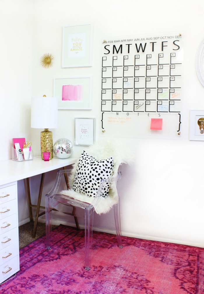 Arbeitszimmer in Weiß und Rosa, Kunststoffstuhl, Schreibtisch aus Holz, Kalender an der Wand, rosafarbener Teppich