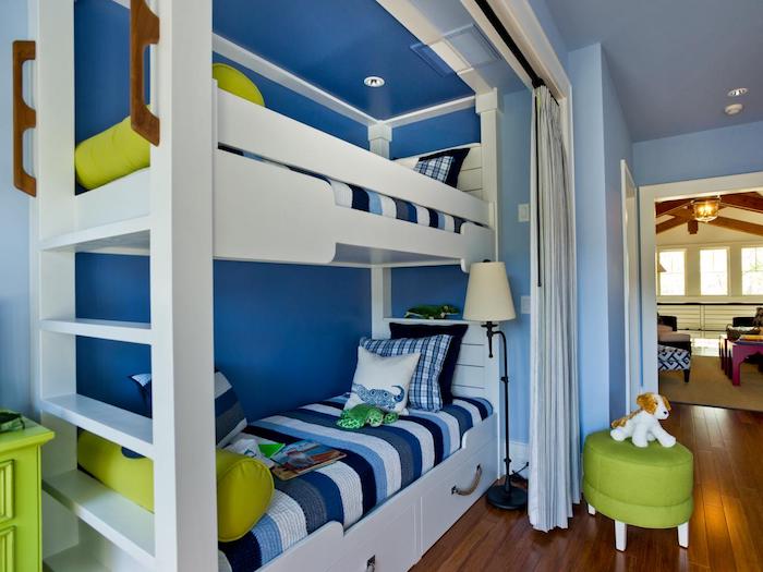 ein blaues Zimmer für zwei Jungen mit einem hohen weißen Kinderbett