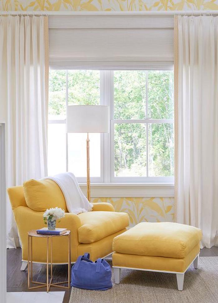 gelb gestaltetes Wohnzimmer mit kleinem Beistelltisch neben dem Relaxsessel mit Hocker