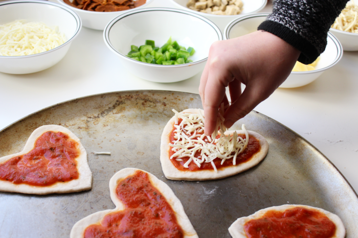 Schnelle Partyrezepte, herzförmige Mini-Pizza, mit Käse garnieren, tolle Ideen für Geburtstagsparty