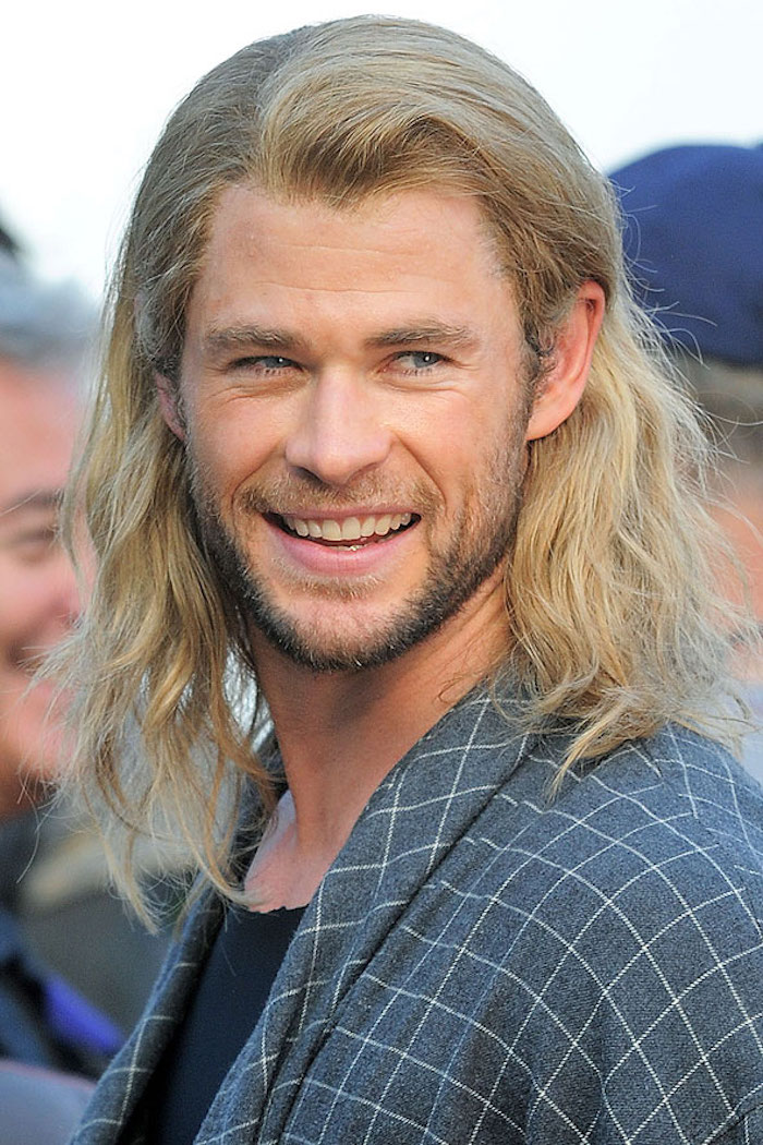 Chris Hemsworth mit langen blonden Haaren und schwarzem Bart auf einem Event