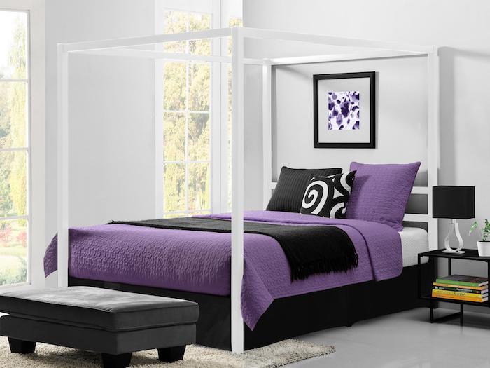 Doppelbett mit Baldachin, weiße Laken und Bettdecke in viollet, zwei schmale Fenster