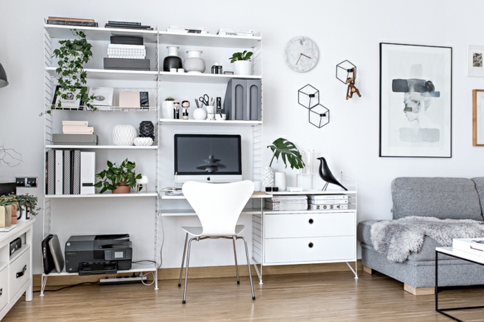 Arbeitszimmer in Weiß, Holzmöbel, grüne Pflanzen, graues Sofa, vielfältige Wanddeko 