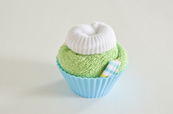 Grünes Tuch und weiße Babysöckchen zum Cupcake rollen, kreatives Babygeschenk, Schritt Sechs