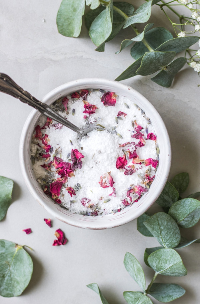 hausgemachtes Badesalz mit Rosenblüten in Porzellan Schale, Rosenblätter daneben, schnelles und einfaches Rezept