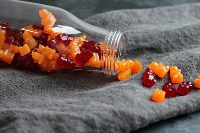 eine Flasche voller selbstgemachte Gummibärchen in oranger und roter Farbe - Gummibärchen selber machen