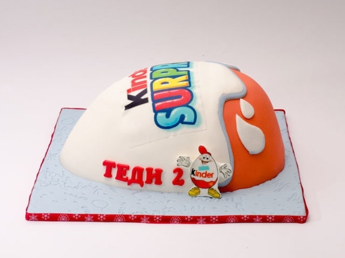 Kinder Überraschung mit dem Logo in Rot und Weiß und bunte Buchstaben - Torte aus Kinderschokolade