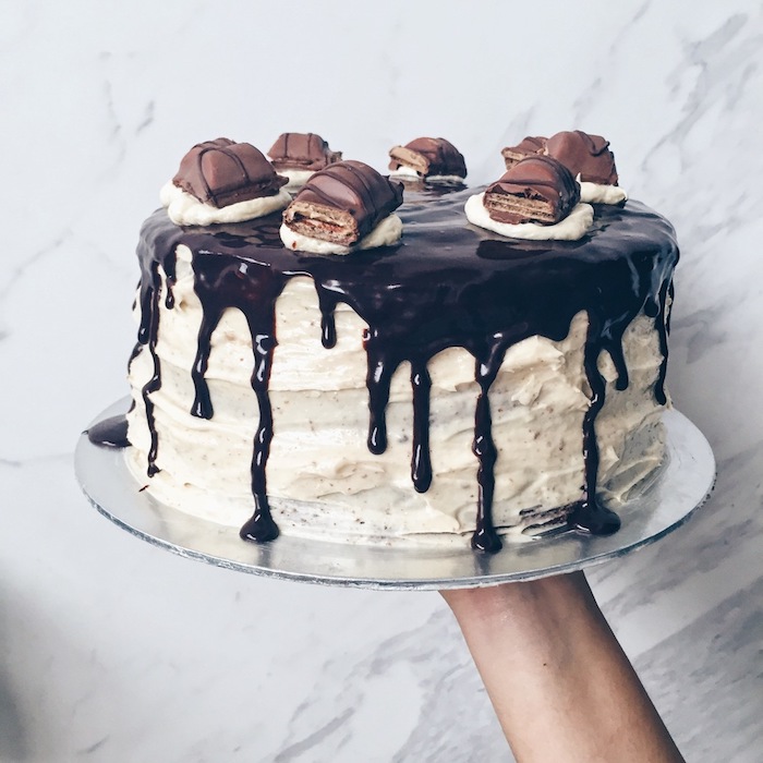 eine Torte mit einer weißen Creme und Schokoladenglasur - Kuchen mit Kinderriegel