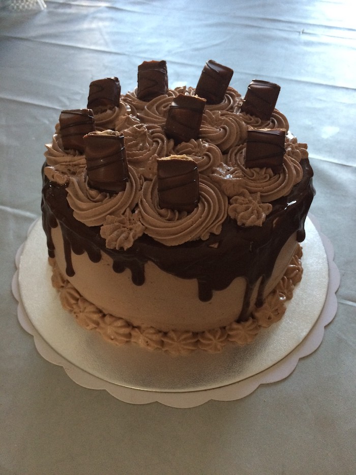 Süßigkeiten Torte mit Schokoladenglasur und Stücke von Kinderriegel als Dekoration