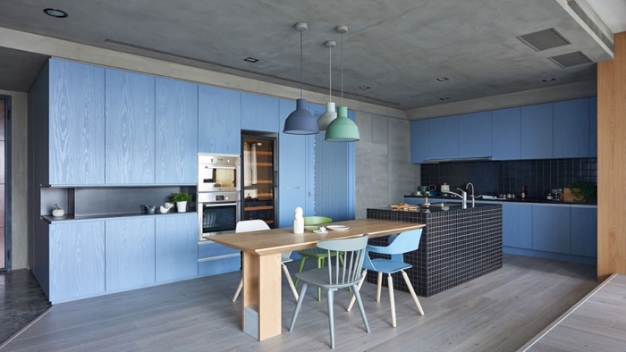 große blaue schränke, küchen aktuell bilder, tisch aus holz, wände in betonoptik
