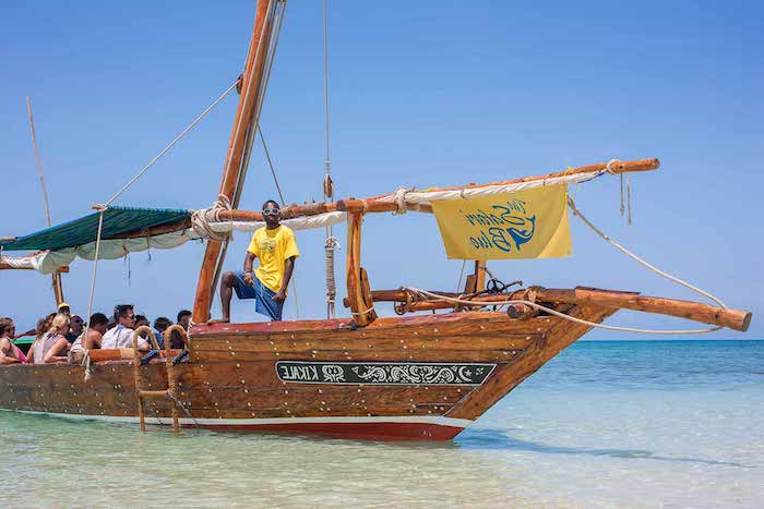 sansibar karte bild von einem boot das zum safari blue fährt wassersafari reiseleiter mann mit gelbem t-shirt