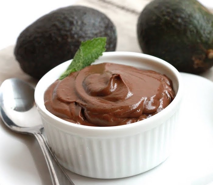 schokoladenherstellung mousse schoko pudding aus avocado und kakaomasse minzenblatt löffel schüssel teller