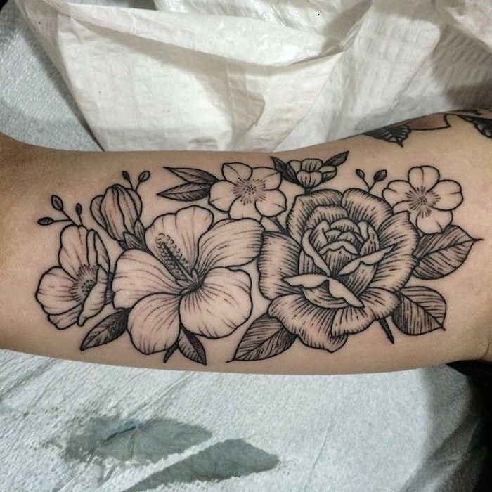 tattoo blume, schwarz-graue blüten am oberarm, tattoos für frauen