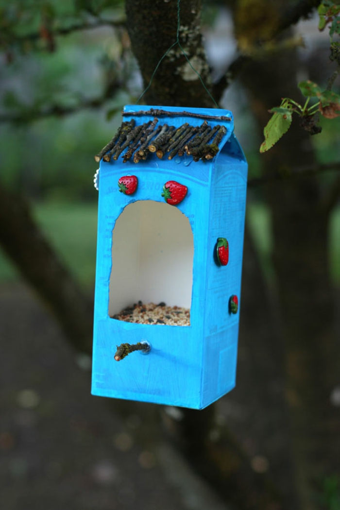Vogelfutterhaus aus Milchkarton selber basteln, mit kleinen Erdbeeren aus Keramik und Stäbchen verzieren