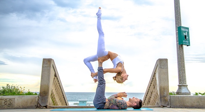 Yoga Vidya Vertrauensübungen, zwei glückliche junge Menschen lächeln, Steintreppen mit einer Säule mit einer grünen Kisse, Реттунгсстелле