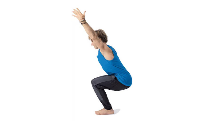 Yoga für Anfänger: Utkatasana Übung, kniender Mann mit hochgestreckten Armen, drei schwarze Armbänder, Mann mit hellen Haaren im Sportoutfit