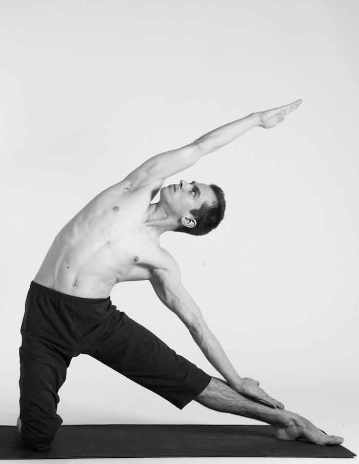 Parighasana Yoga Position, Mann mit gestrecktem linken Bein und Blick, gerichtet nach oben, schwarze Sporthose bis zum Knie