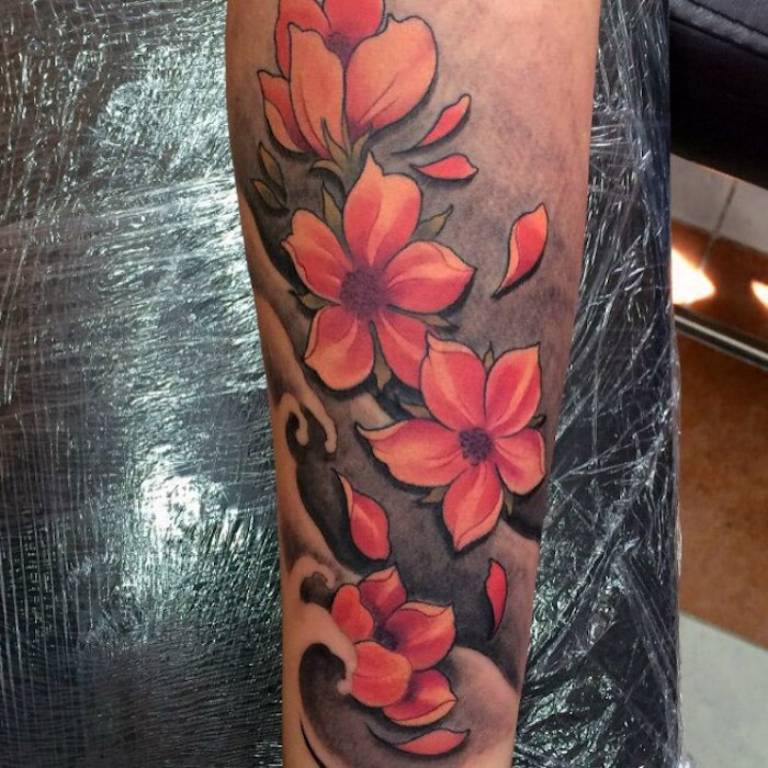 kirschblüten tattoo am unterarm, tätowierung mit wasserwellen und roten blüten