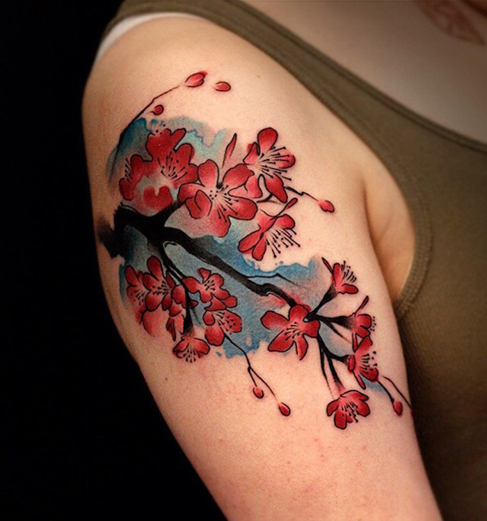 kirschblüten tattoo, frau mit farbiger tätowierung am schulter
