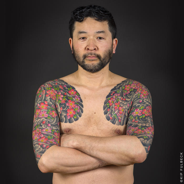 japanische tattoos, mann mit großen tätowierungen mit wasserwellen und kirschblüten