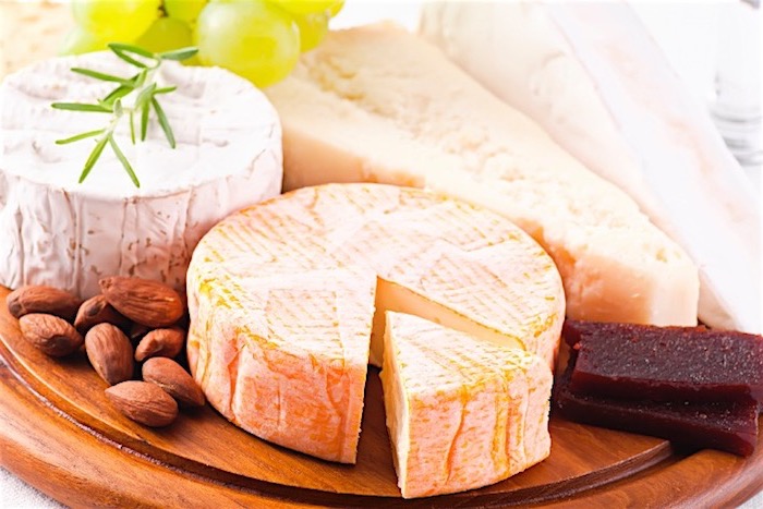 Brie- und Camemberkäse, ein großes Stück Parmesan, rohe Madeln und Weißweintrauben als Deko, zwei Stücke türkische Patirma