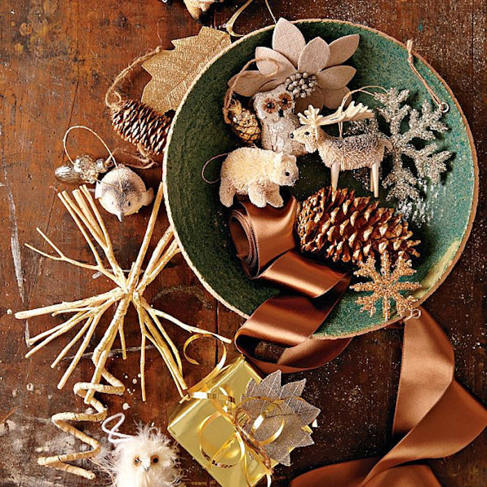 Weihnachtstischdeko schüssel voll mit kleinen dekoelementen zu weihnachen zapfen kleine figuren weihnachtsbaum schmuck schleife braun