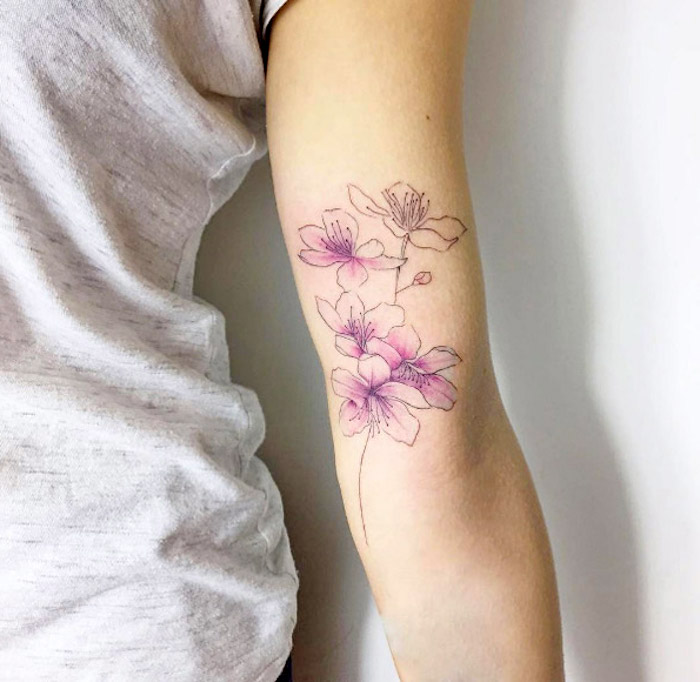 tattoos mit bedeutung, farbige tätowierung mit kirschblüten-motiv, blumen tattoos
