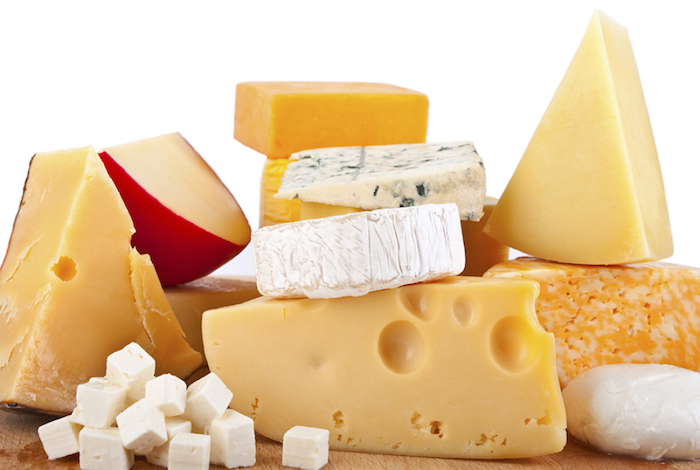 ein Bild mit weißem Hintergrund, das einige Sorten von hartem und weichem Käse zeigt, gewürfelter Weißkäse und ein Mozzarellabällchen, ein quadratischer Stück Cheddar, ein Triangelstück Schimmelkäse