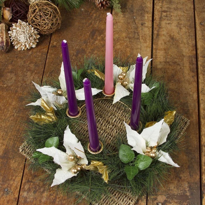 weihnachtsdekoration . ein adventskranz mit weißen blumen, vier lila und pinken kerzen und ästen mit grünen blättern - adventskranz selbst basteln