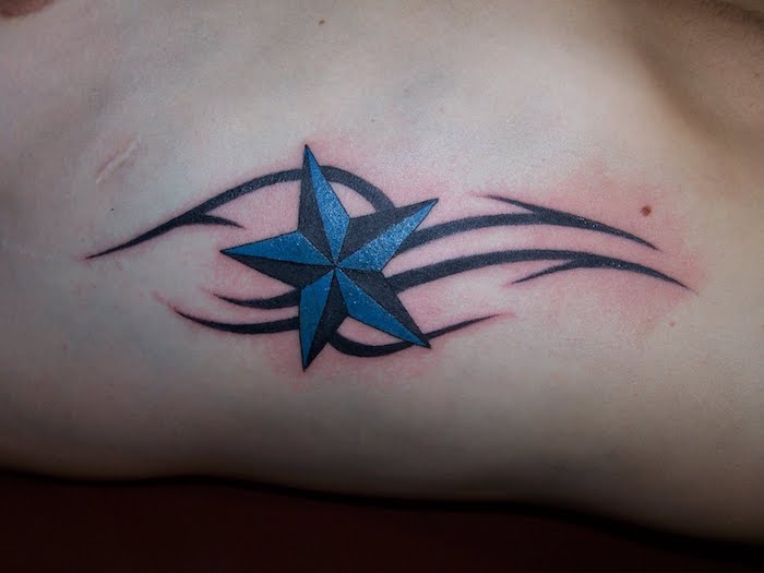 mensch mit einem stern tattoo - eine schwarze tätowierung mit einem großen blauen stern