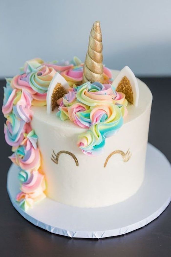 einhorn torte anleitung - eine torte mit einem weißen einhorn mit einem kleinen goldenen horn und mit einer bunten mähne aus sahne