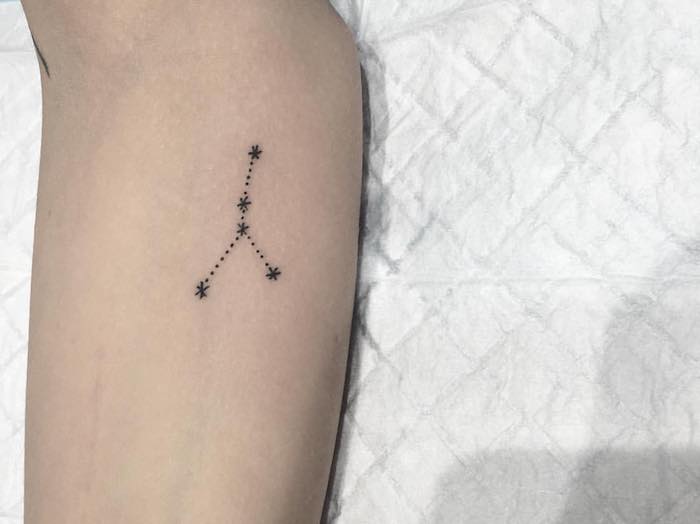 kleiner schwarzer tattoo mit einem schwarzen sternbild mit kleinen schwarzen sternen - eine hand mit stern tattoo