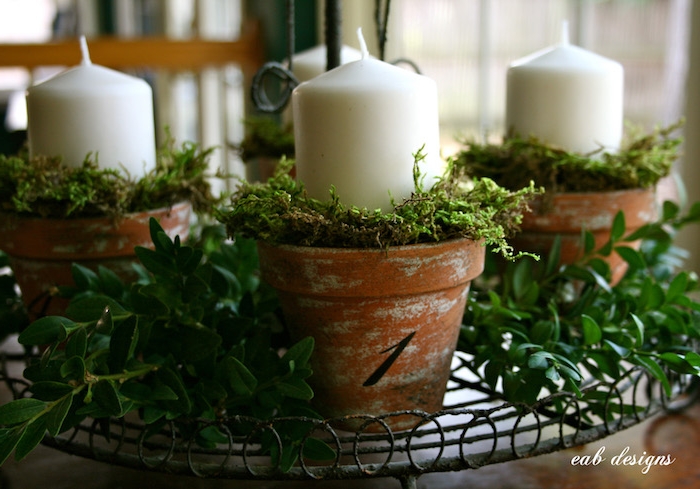 blumentöpfe mit grünen pflanzen und weißen kerzen - einen adventskranz selber machen 
