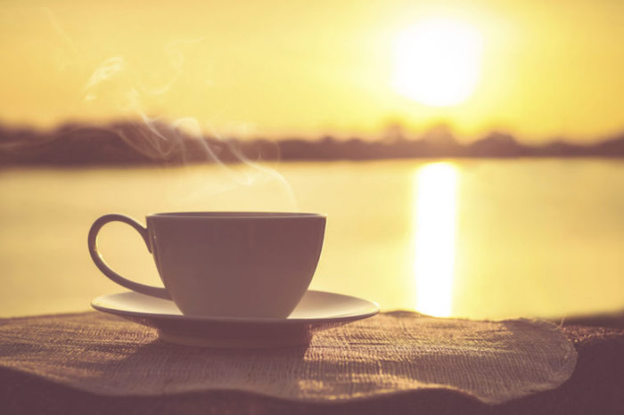 Guten Morgen Bilder - eine Tasse Kaffee mit Dampf im Hintergrund des Sonnenaufgangs