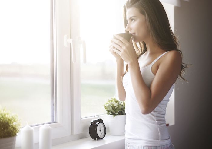 Guten Morgen Bilder - ein Mädchen genießt Kaffee und sieht durch das Fenster